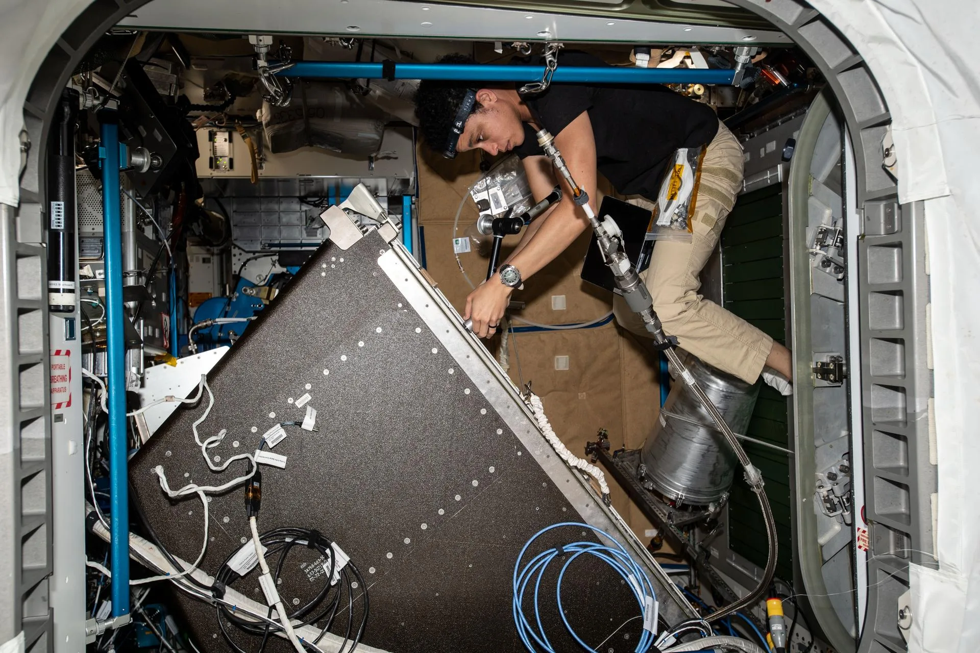 NASA astronotu Jessica Watkins, 1 Haziran 2022'de Tranquility modülündeki Su Geri Kazanım Sistemi rafının yaşam destek bileşenlerine bakım yapıyor. Bu raf, idrarı ve atık suyu içme suyuna dönüştüren döngünün kalbi.