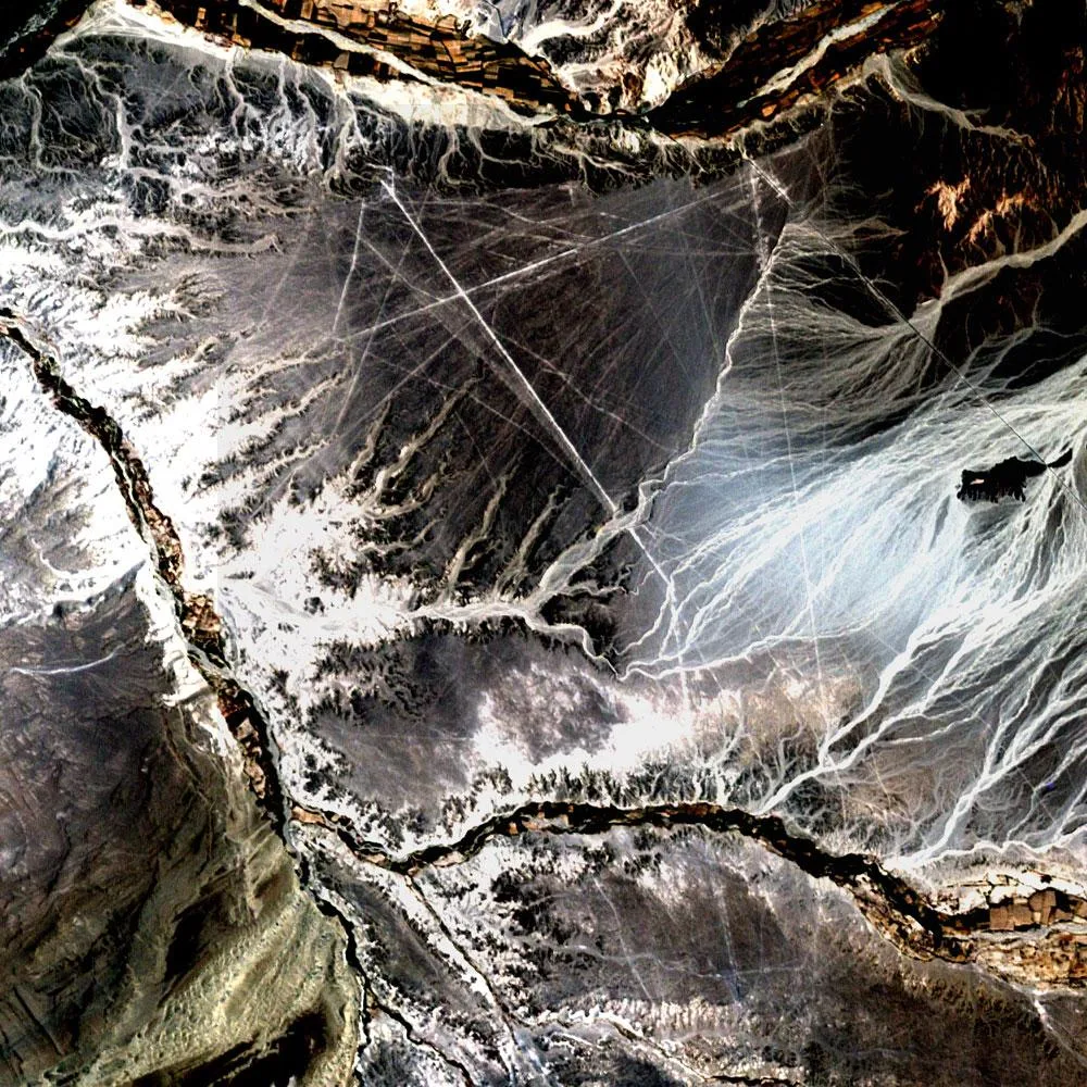 NASA'nın Landsat 7 uydusunun 10 Kasım 2002'de çektiği görüntüde Peru'nun güneyindeki Nazca platosu. Uydunun çözünürlüğünde ancak en uzun düz çizgiler seçilebiliyor; figürler 10-15 santimetre derinliğinde sığ oluklardan oluşuyor.