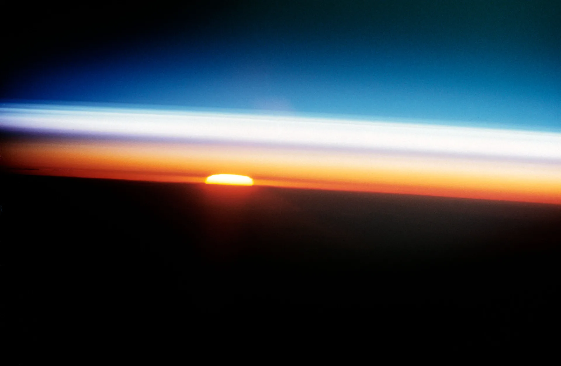 Uzay mekiği Columbia'dan 1992'de çekilen gün batımı fotoğrafında atmosferin katmanları. Mor tonlu alt kısım troposferi, beyaz katmanın üstü stratosferin üst sınırını gösteriyor.