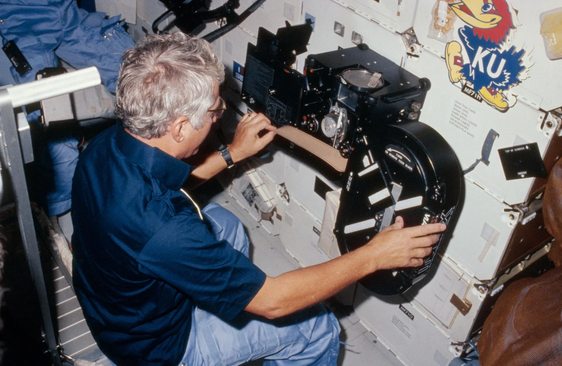 STS-41-D görevi, Eylül 1984: komutan Henry Hartsfield, mekiğin orta güvertesinde süzülen IMAX kamerasına film yüklüyor.