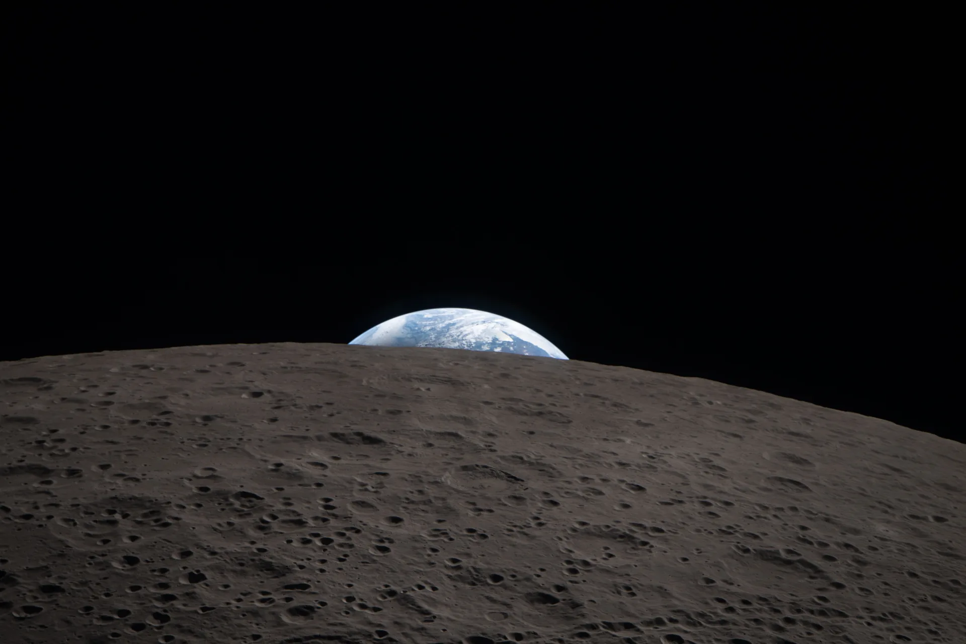 Artemis II astronotlarının 6 Nisan 2026'daki Ay geçişinde, Ay'ın uzak yüzünün arkasında batan Dünya'yı gösteren fotoğrafı. Kare, Apollo 8'in 1968'deki ünlü "Dünya Doğuşu" fotoğrafını hatırlatıyor.