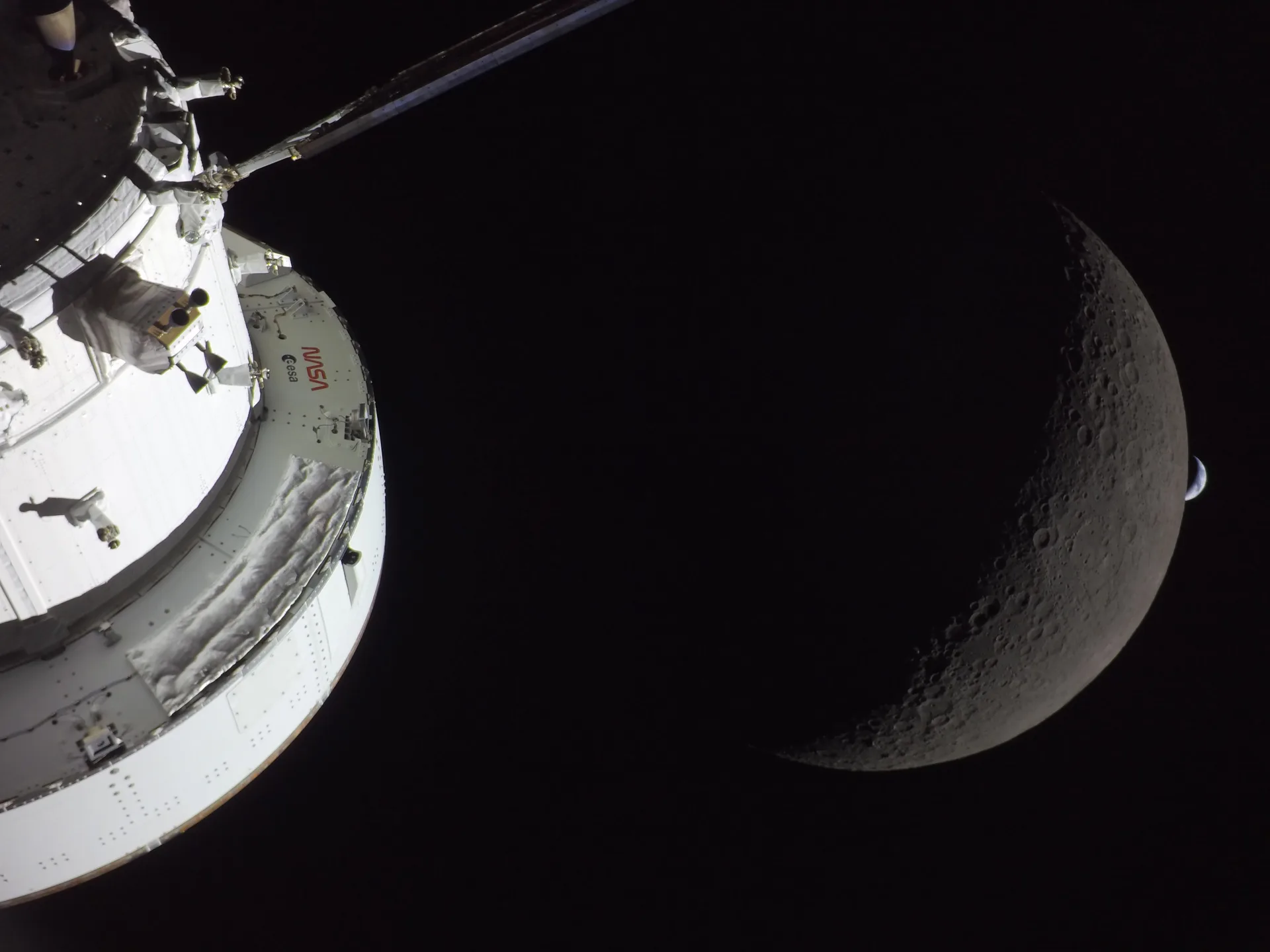 Artemis II görevinin altıncı gününde Orion aracının kamerasından Ay ve arkasında batmak üzere olan hilal biçimli Dünya. İki cismin ortak bir geçmişi olduğu düşünülüyor.
