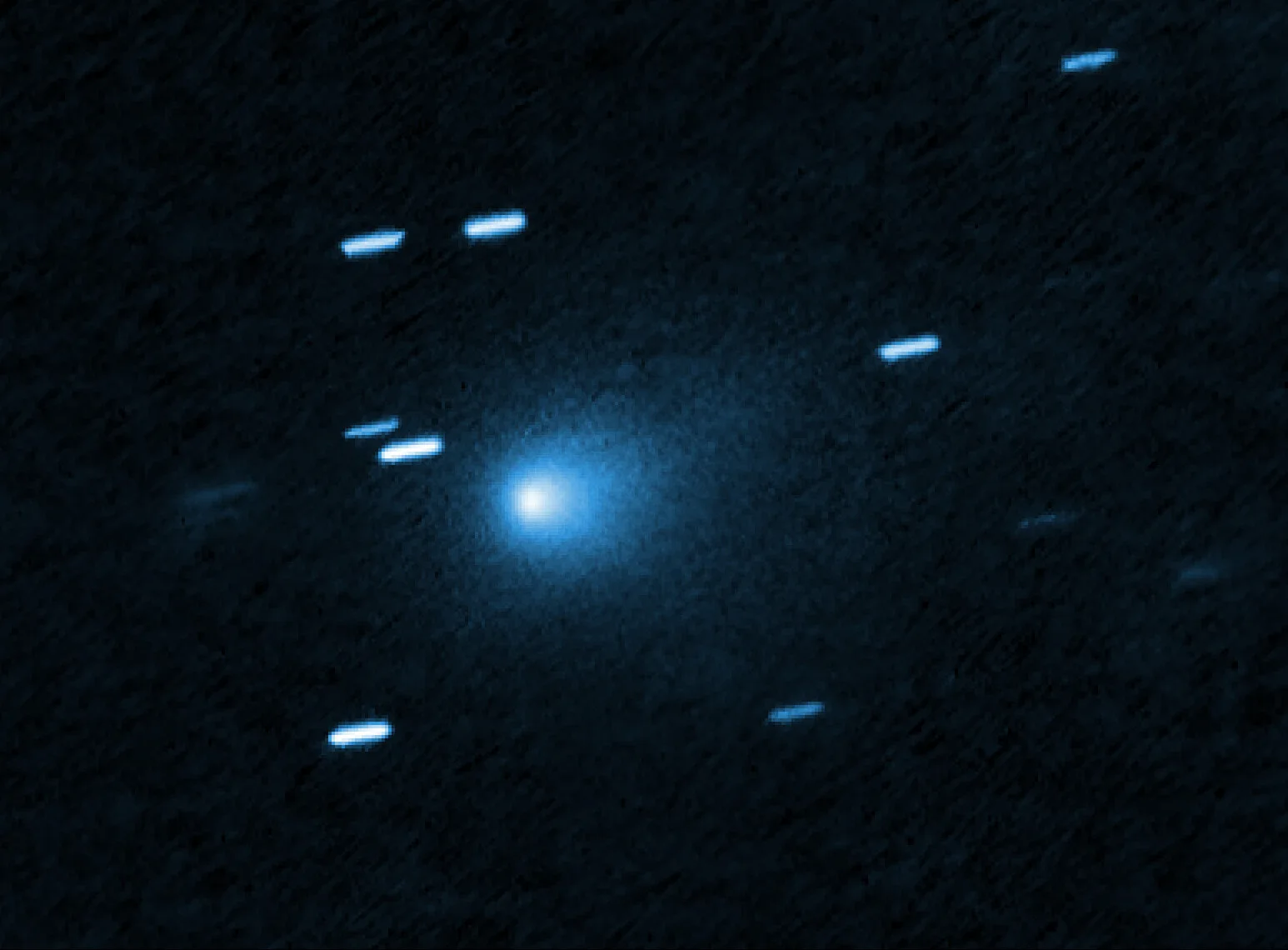 Hubble Uzay Teleskobu'nun 21 Temmuz 2025'te çektiği 3I/ATLAS. Kuyruklu yıldızın çekirdeğinden Güneş'e doğru uzanan toz, damla biçimli bir koma oluşturuyor; arka plandaki çizgiler, teleskop hızlı cismi izlerken kayan yıldızlar.
