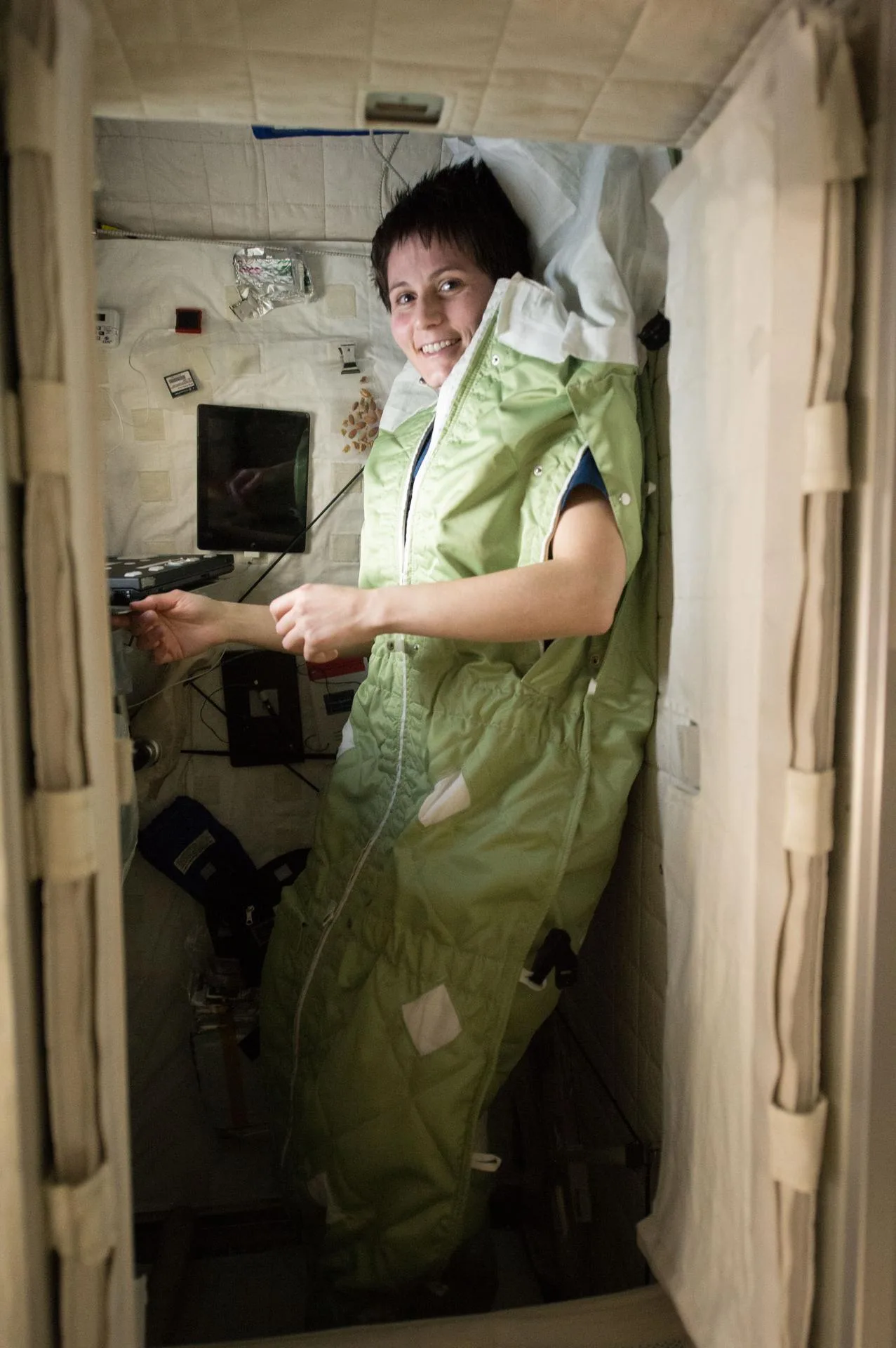 ESA astronotu Samantha Cristoforetti kendi uyku kabininde. Uyku tulumu duvara bağlanır; aksi halde uyuyan kişi modülün içinde serbestçe sürüklenir.