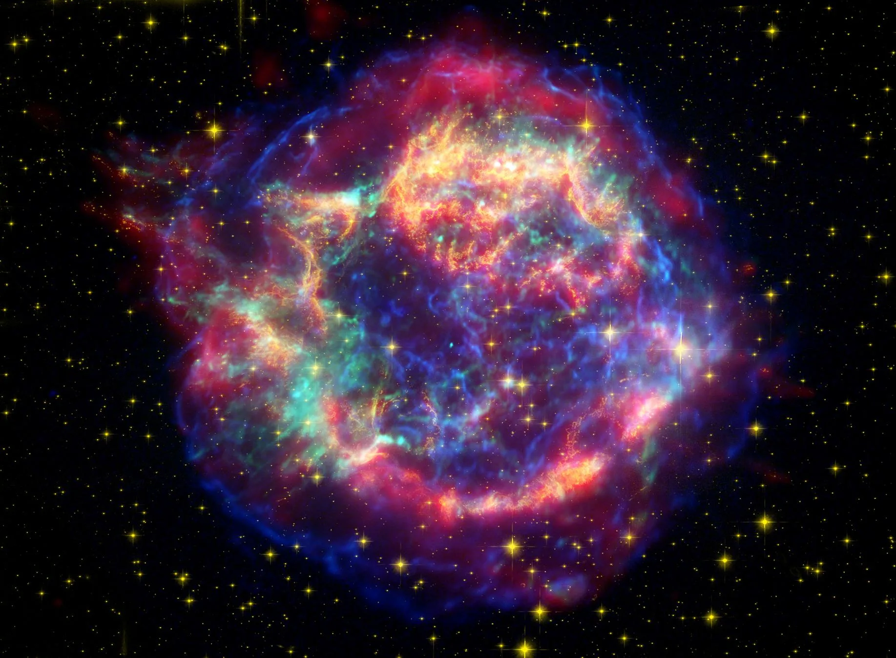 Cassiopeia A süpernova artığı, NASA'nın üç büyük gözlemevinin verilerinden oluşturulmuş yapay renkli görüntüde. Patlamadan geriye kalan genişleyen kabuk ve ısınmış gaz.