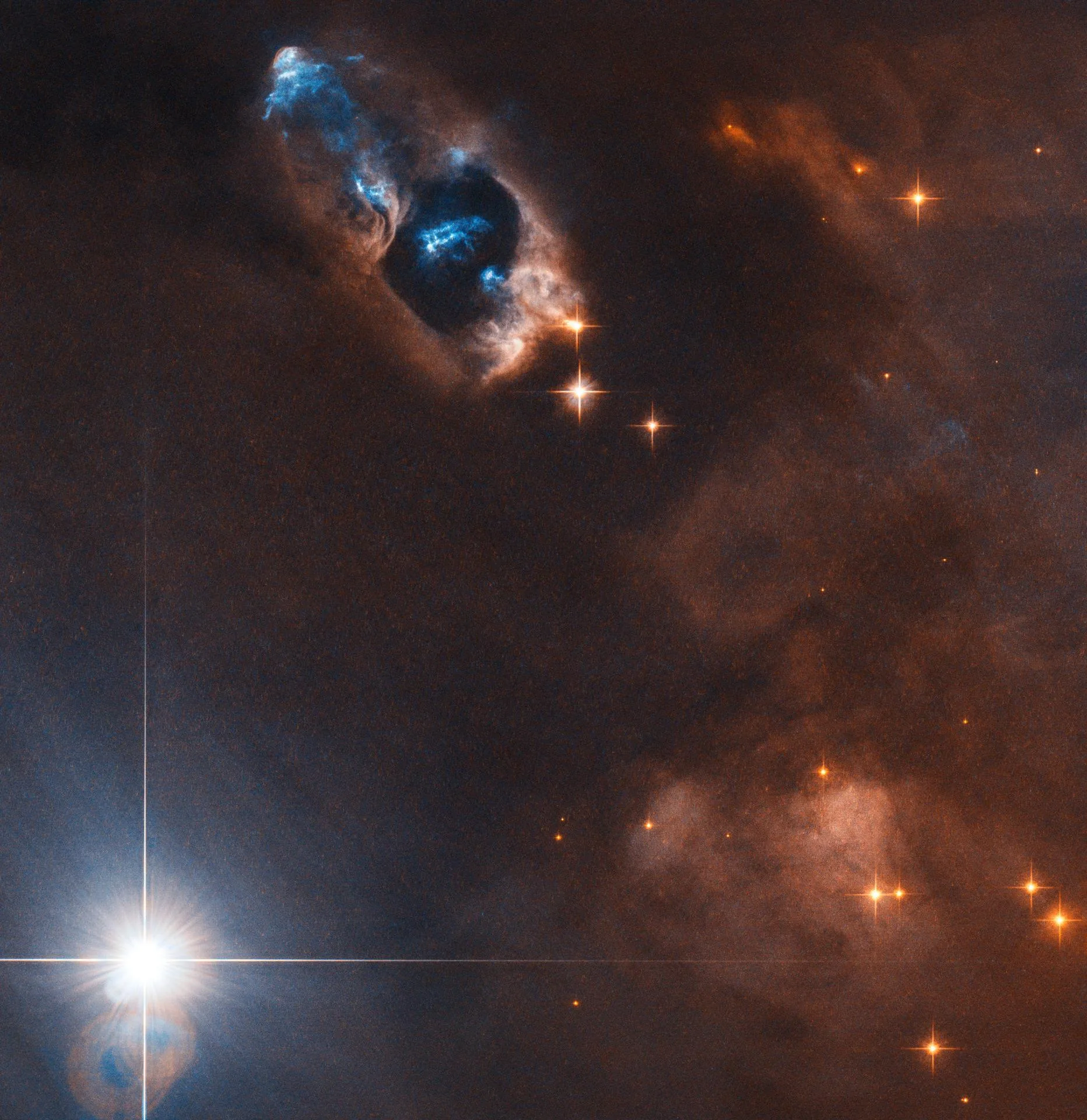 Hubble'ın görüntülediği, NGC 1333 bulutsusundaki HH 7–11 nesneleri: Genç yıldız SVS 13'ün fırlattığı madde parlak mavi lekeler olarak görünüyor