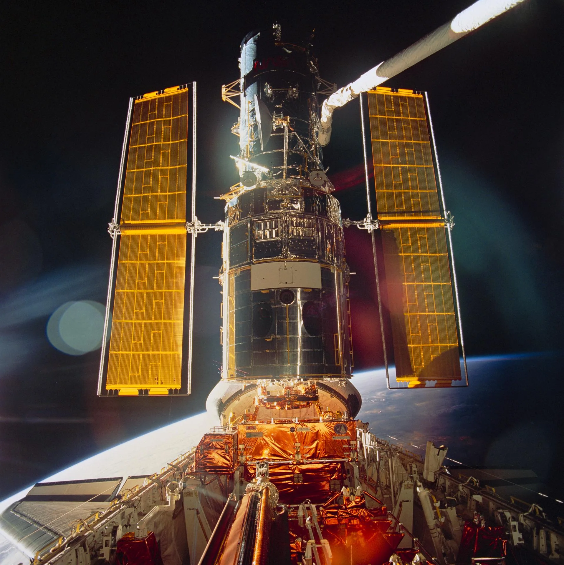 Aralık 1993, ilk Hubble bakım görevi: teleskobun yeni güneş panelleri açılmış hâlde, Endeavour mekiğinin arka pencerelerinden görünüyor.