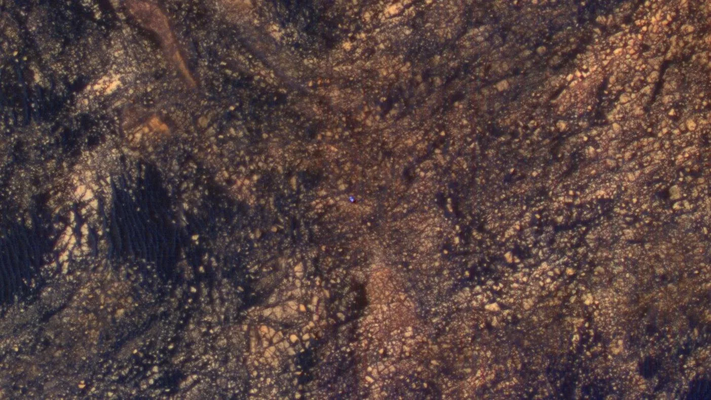Mars Reconnaissance Orbiter'ın HiRISE kamerasının 5 Haziran 2017'de çektiği bu görüntünün ortasındaki parlak mavi nokta, Sharp Dağı'nın kuzeybatı yamacındaki Curiosity.