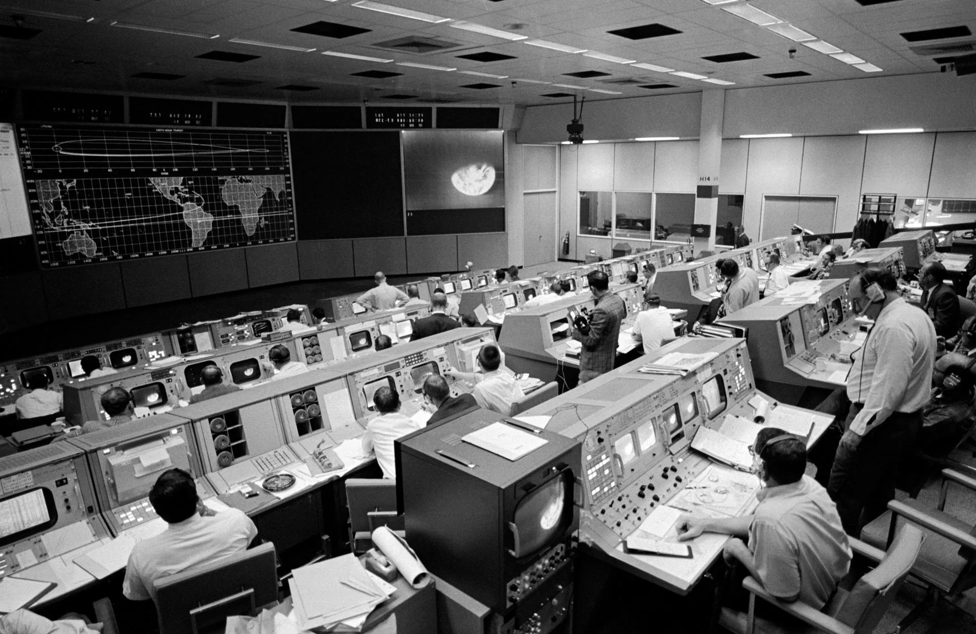 Apollo 8'in üçüncü gününde Houston'daki Görev Kontrol Merkezi; ekranda araçtan gönderilen Dünya görüntüsü var