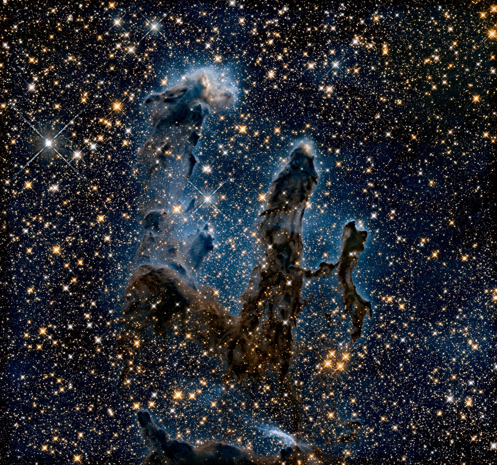 Hubble'ın 2014'te yakın kızılötesinde yeniden görüntülediği sütunlar; bu dalga boyunda yapılar hayalet gibi siluetlere dönüşüyor.