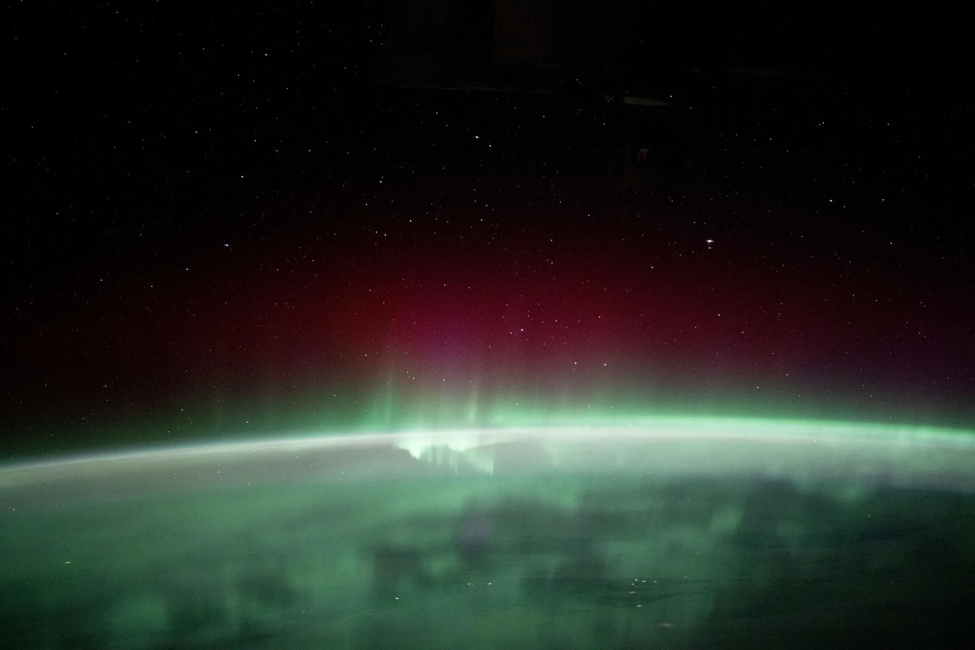 Uzay istasyonundan Kanada'nın Manitoba eyaleti üzerinde görülen kuzey ışıkları. Aurora, Güneş'ten gelen yüklü parçacıkların üst atmosferdeki gazlarla etkileşmesiyle oluşur.