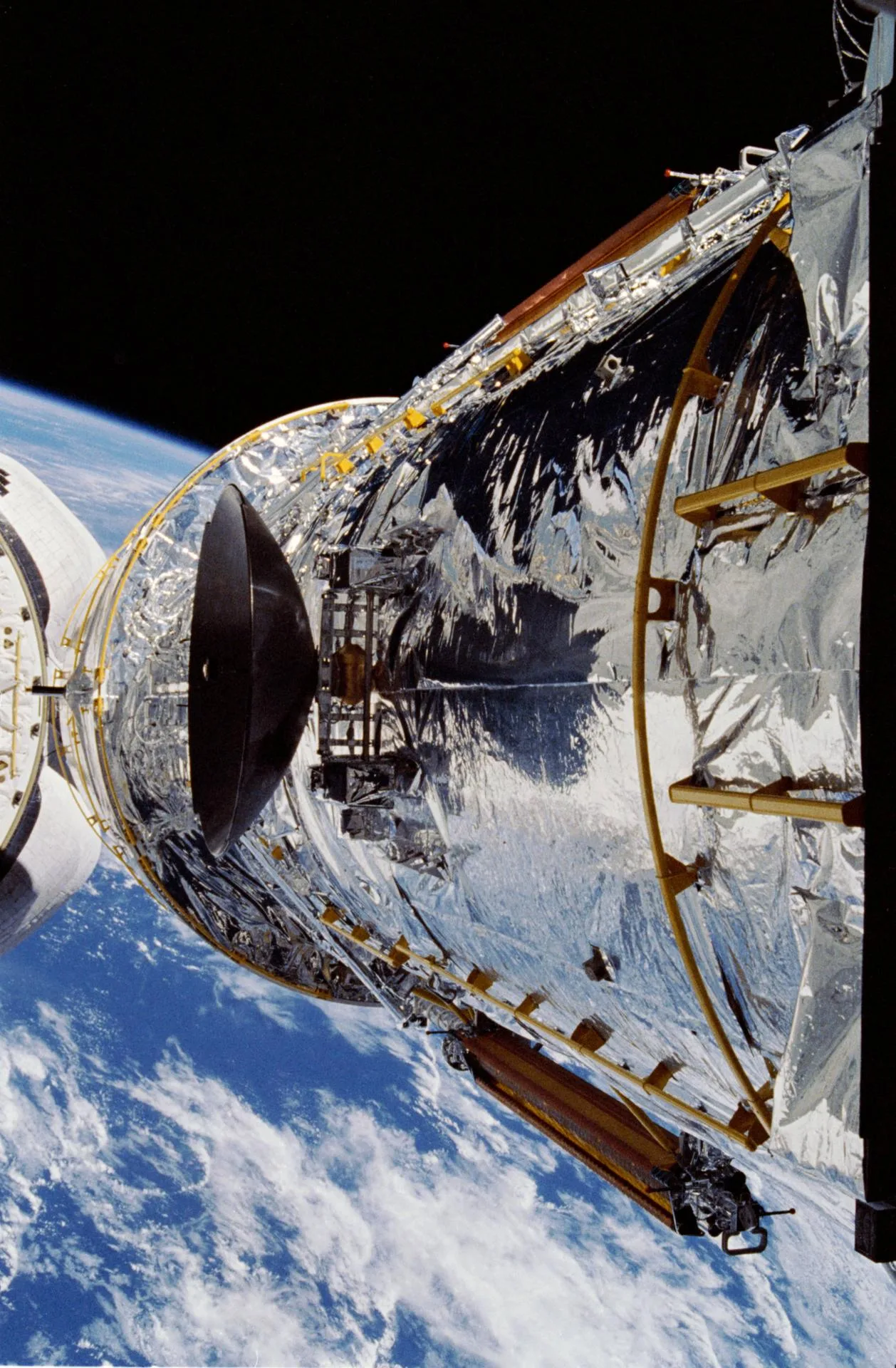 Hubble Uzay Teleskobu, Nisan 1990'da STS-31 görevinde Discovery'nin yük bölmesinin üzerine kaldırılırken.