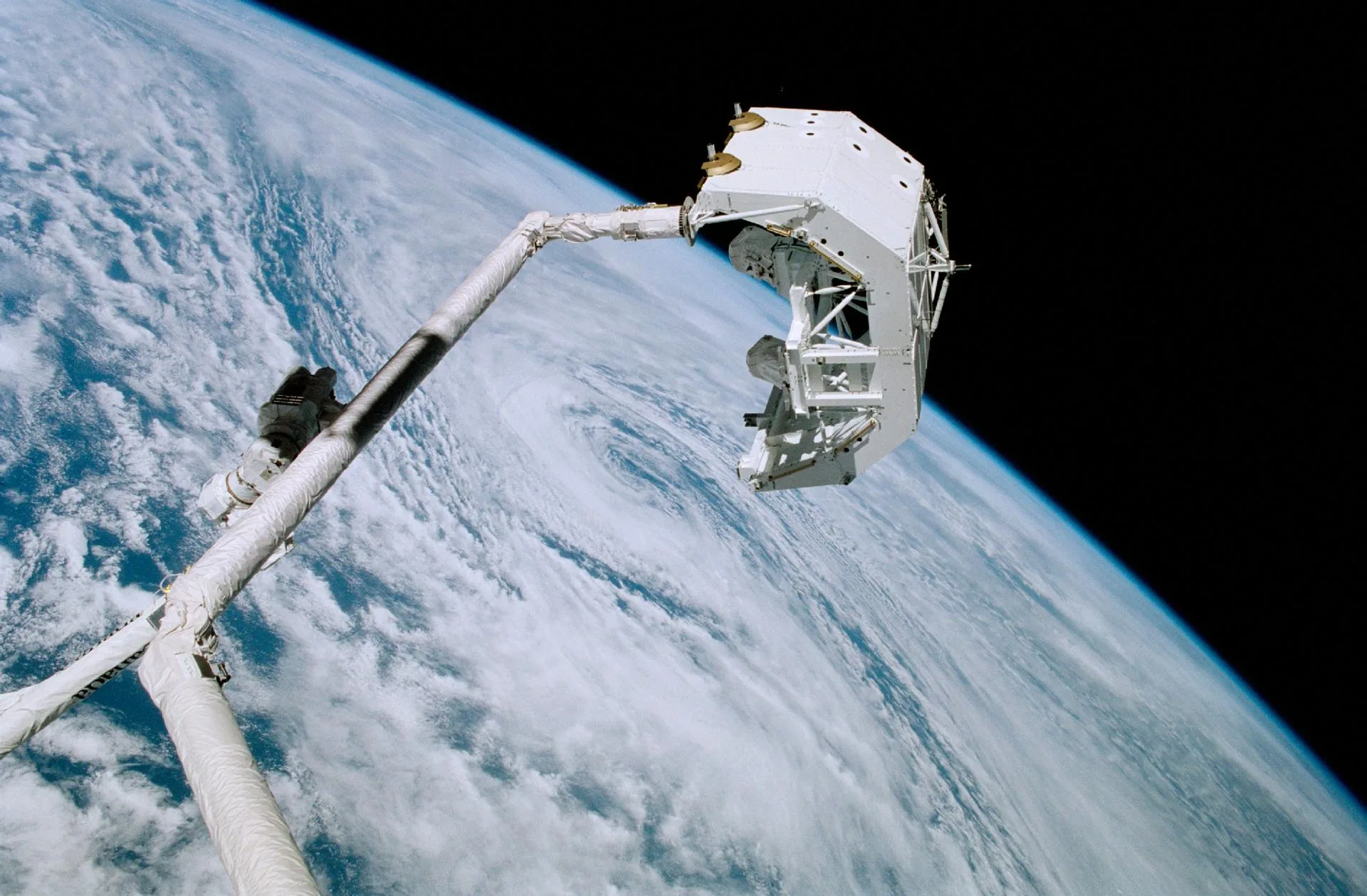 Kanada yapımı istasyon robot kolu Canadarm2, Nisan 2001'de fırlatma platformunu Endeavour mekiğinin robot koluna devrederken: uzayda bir "el sıkışma".