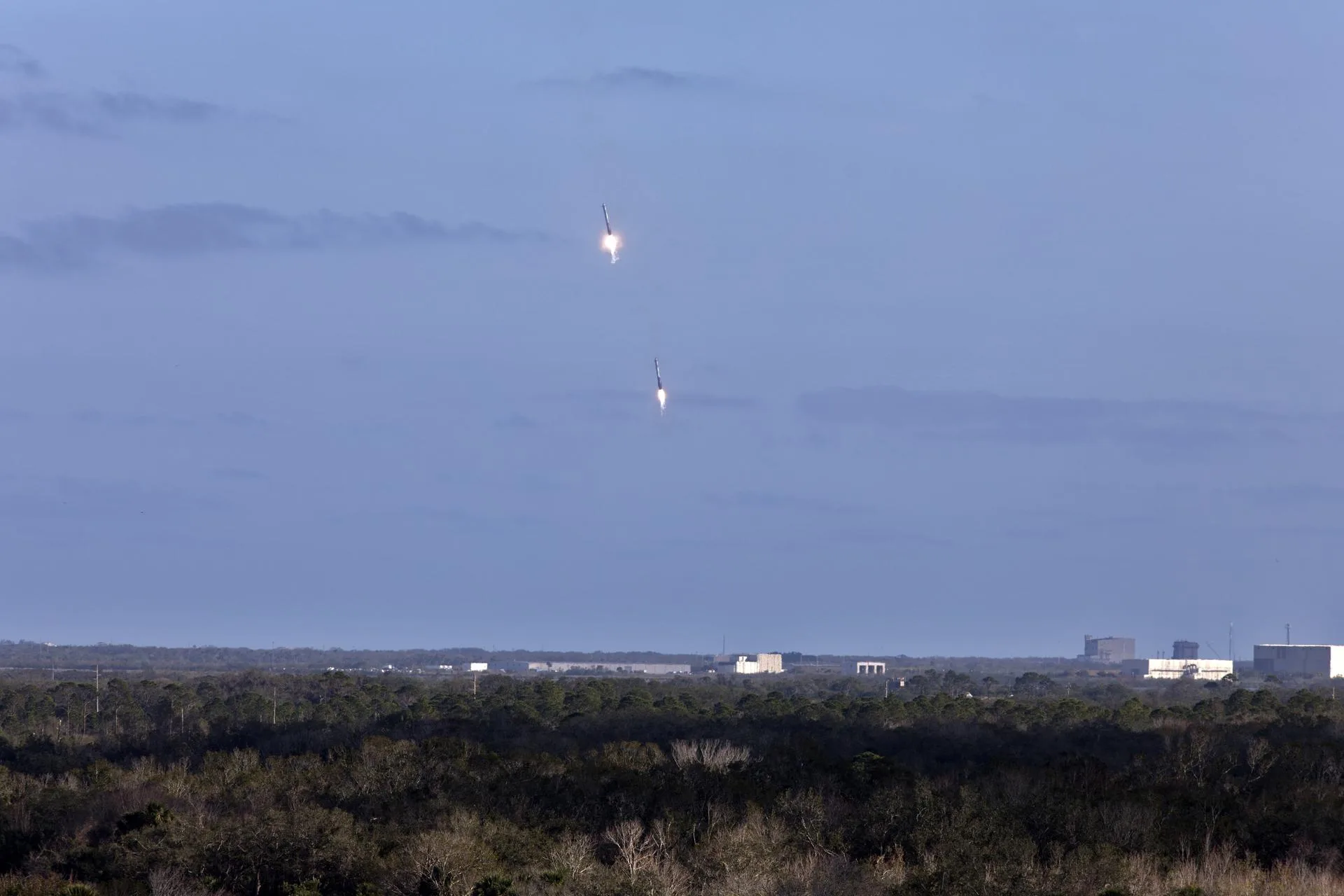 Falcon Heavy'nin iki yan iticisi, ilk uçuşun ardından Cape Canaveral'daki iniş alanlarına eşzamanlı olarak alçalıyor (6 Şubat 2018).