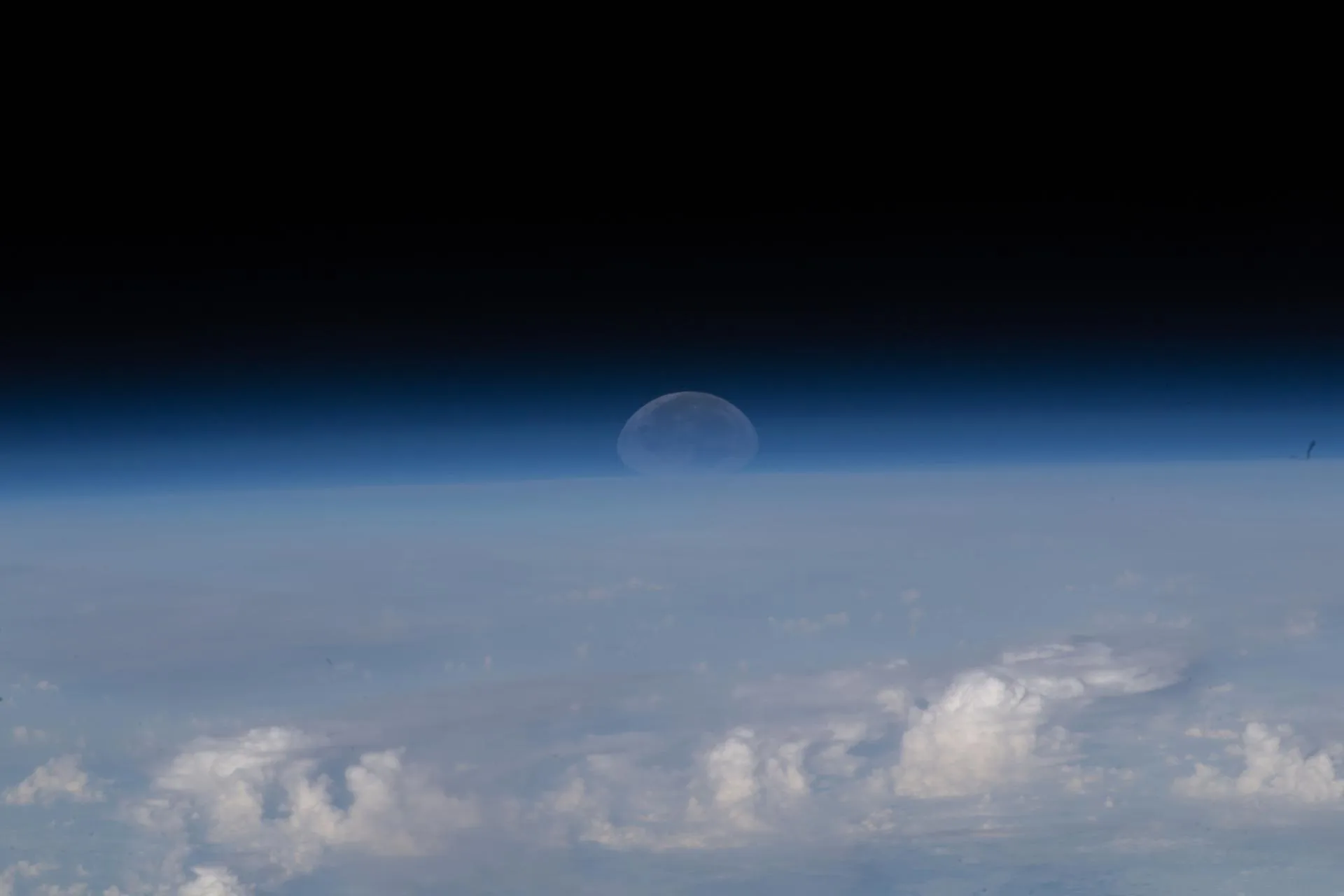 Katmandu yakınlarında Himalayalar üzerinde batan Ay: atmosfer ışığı kırdığı için Ay basık görünüyor (Uluslararası Uzay İstasyonu)