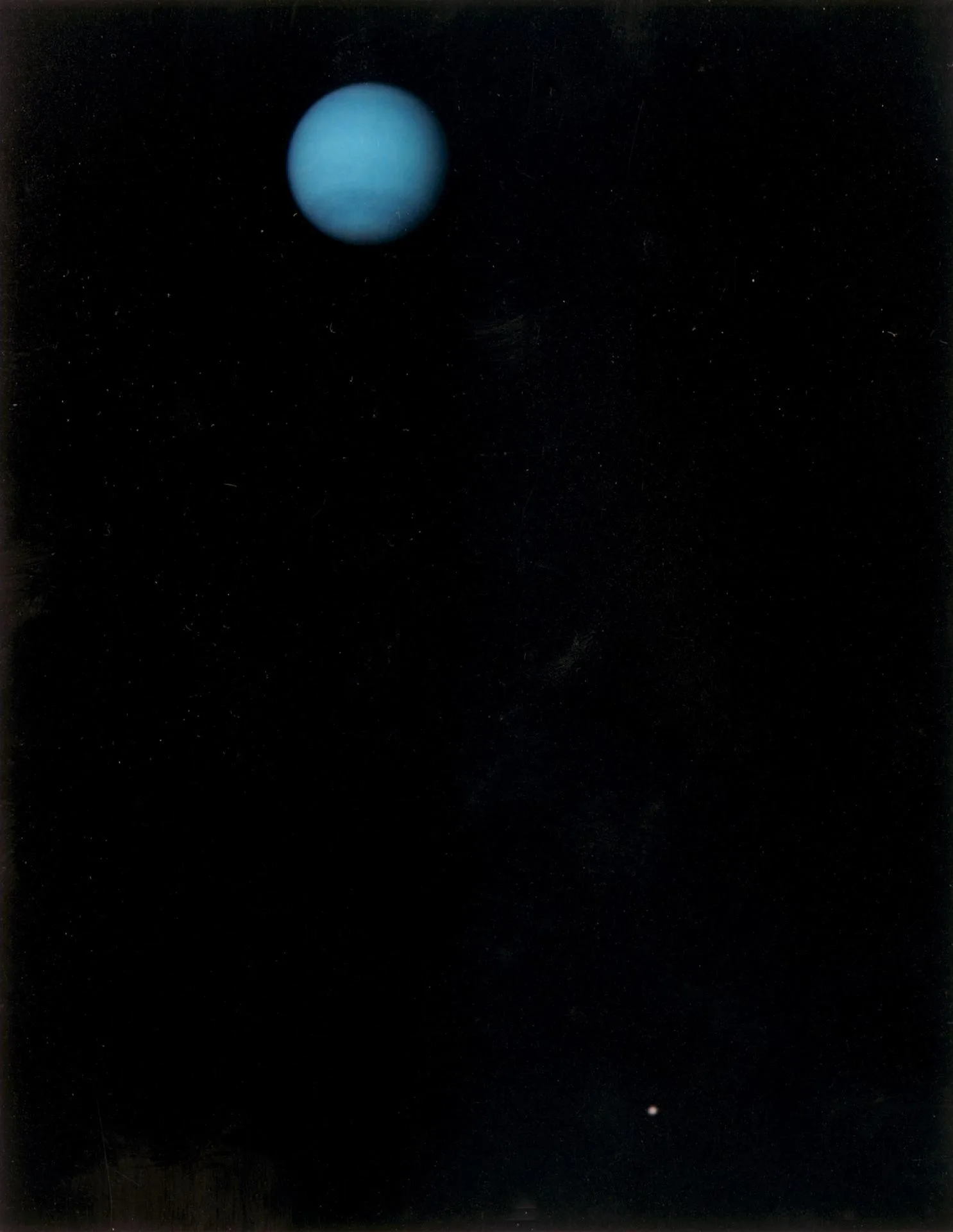 Voyager 2'nin 1989'da Neptün'e yaklaşırken çektiği, gezegeni ve en büyük uydusu Triton'u birlikte gösteren görüntü