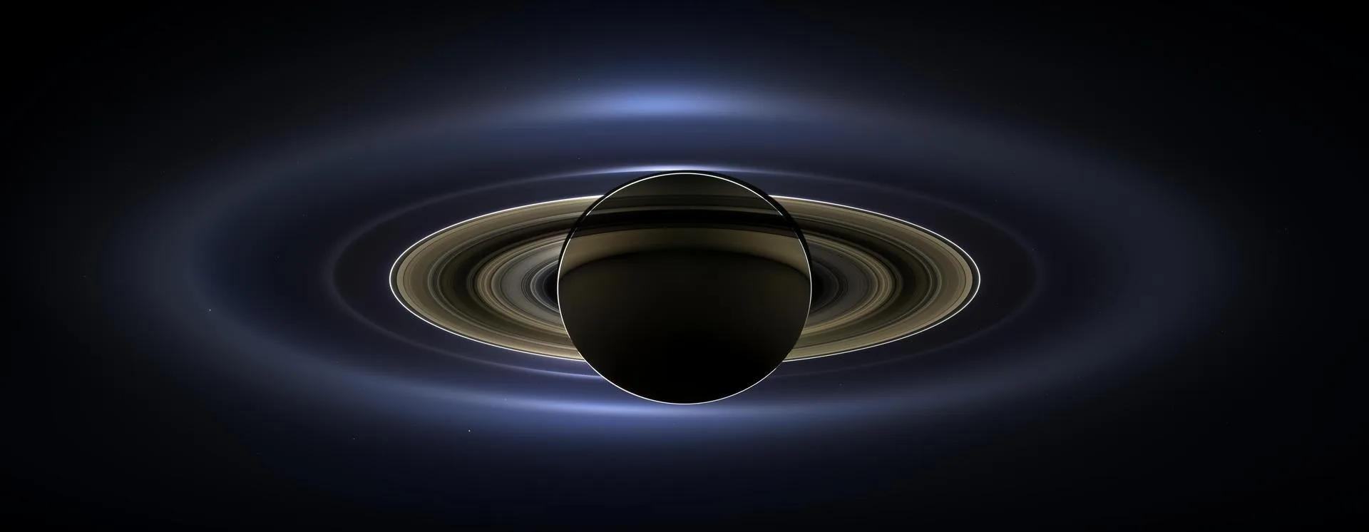 Cassini'nin 19 Temmuz 2013'te Satürn'ün gölgesinden çektiği arka aydınlatmalı Satürn, halkalar ve uzakta Dünya (“Dünya'nın Gülümsediği Gün”)