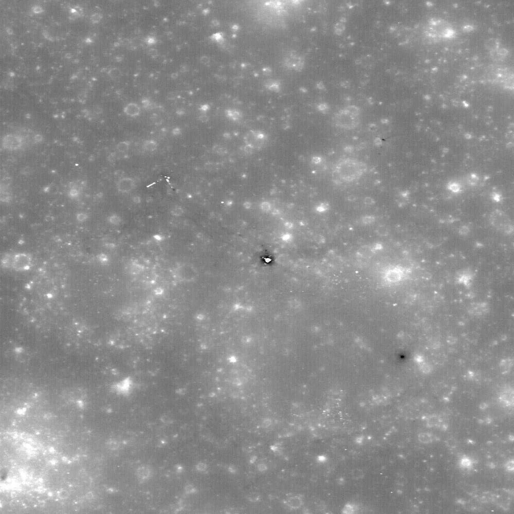LRO'nun haritalama yörüngesinden çektiği, Fırtınalar Okyanusu'ndaki Apollo 12 iniş alanı. Ortadaki parlak nokta ve gölgesi Ay modülünün yüzeyde kalan iniş katını, çevresindeki ince koyu izler astronotların yürüdüğü patikaları gösteriyor.