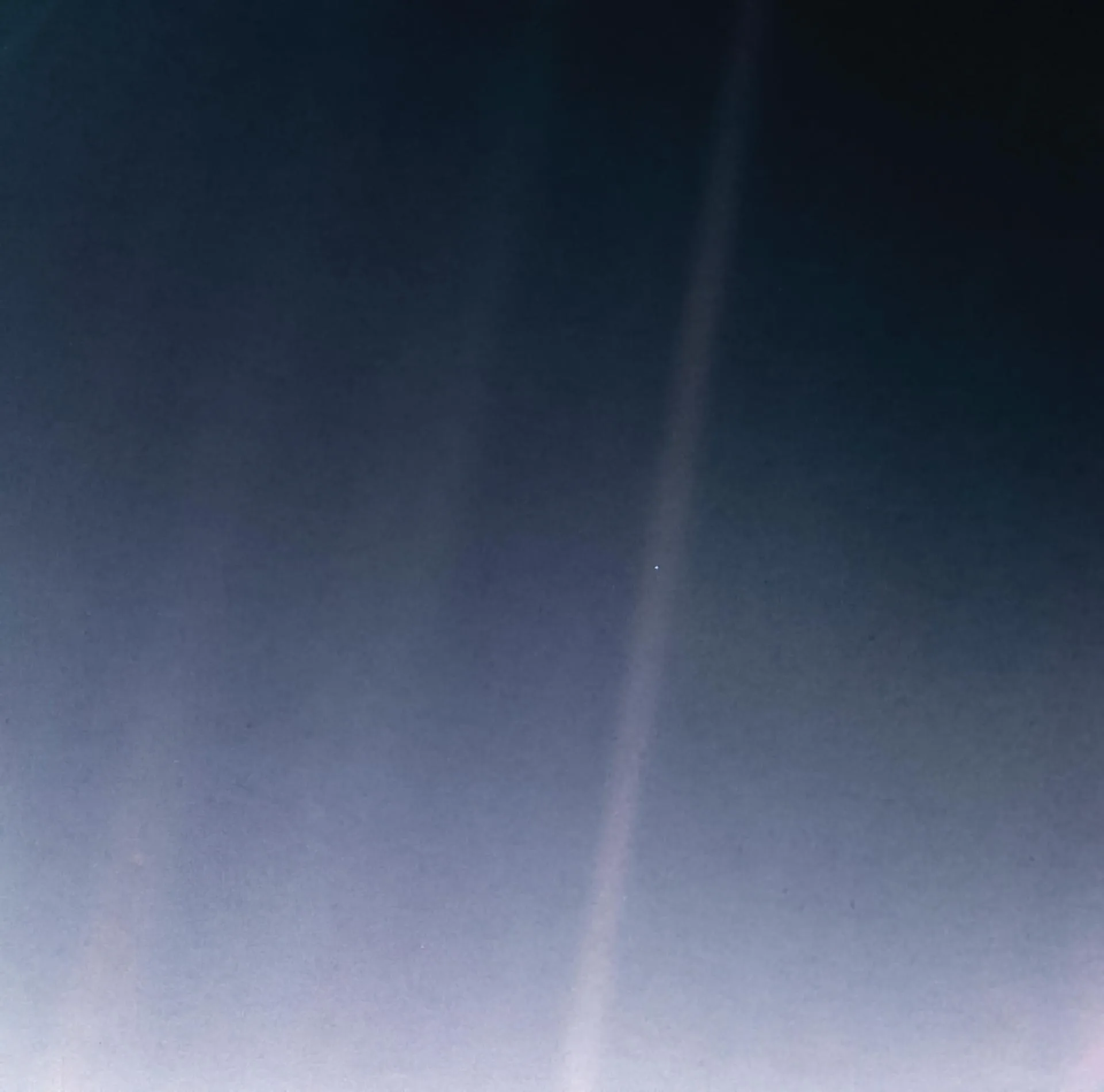 Voyager 1'in 1990'da çektiği 'Soluk Mavi Nokta' görüntüsünün 2020'de yeniden işlenmiş hâli. Dünya, güneş ışığı demetinin içindeki küçük parlak noktadır.